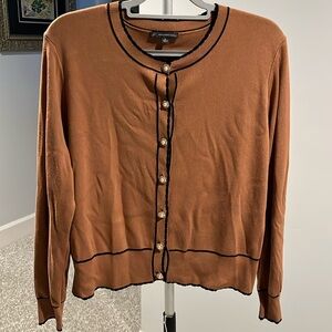 Tan sweater with black detail.